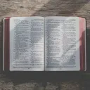 an open Bible on a wood table