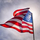 Looking up toward the sky with an American flag flying in the wind.