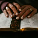 a woman's hands resting on an open Bible