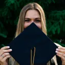 a woman holding up a graduation hat