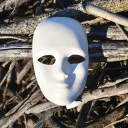 White mask on top of a pile of sticks