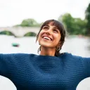 A woman with her arms stretched out lookin up/