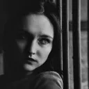 a woman leaning against a fence