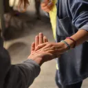 two people standing with one person's hand in the other's outstretched palm