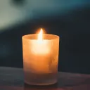 a yellow candle on a wooden table