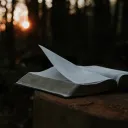 a open Bible against a dark outdoor background