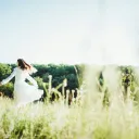 woman in a white dress skipping through a field