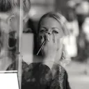 A woman getting makeup put on her in a salon.