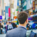 a man dressed in a suit walking in a city