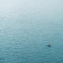 A tiny boat in a big sea of water.