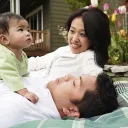 A husband and wife holding their baby.