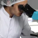 A person looking through a microscope.