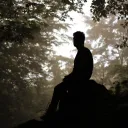 A man sitting on a rock.