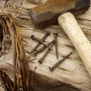 Uma coroa de espinhos, pregos, martelo e poste.