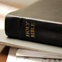 A Bible laying on top of papers.