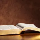 An open Bible laying on a table.