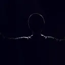 A shadow silhouette of a man with arms in the air.