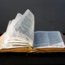 An open Bible laying on a table.