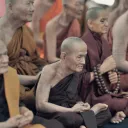 Buddhist monks sitting on the floor.