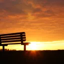 A empty bench with the sun setting.