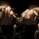 Hands hold heavy chains.