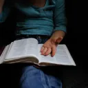 A person with a Bible on their lap.