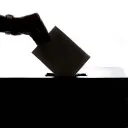 A photo illustration of hand inserting a vote card into a box.