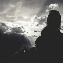 Woman with sun rays in background.