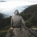 A person sitting on a rock looking over a valley.