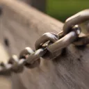 Heavy chain across a piece of wood.
