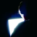 A man looking at a computer screen in a dark room.