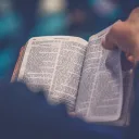 A man holding an open Bible.
