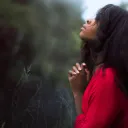 A woman praying while outside.