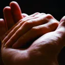 A hand holding another hand - helping up.