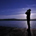 A person looking up to the sky and praying.