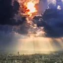 Sun rays and clouds over a big city.
