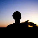 A shadow of young man looking towards the sunset.