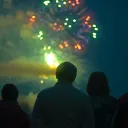 People watching the night sky filled with fireworks.