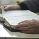 A older person reading a Bible.