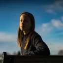 A young woman sitting on a bench.