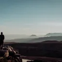 A young man standing on top of a cliff.