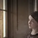 A young woman looking out a window.