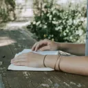 A young woman reading a Bible on a old table.