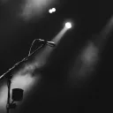 A microphone on a stage lit by a spotlight.