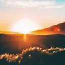 A sun setting over hills.