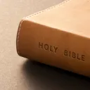 A brown Holy Bible on a table.