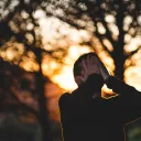 A man with his hands on his face looking up.