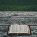 An open Bible laying on a table.