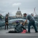 A man giving a donation to a homeless person.
