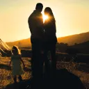 A family in a field at sunset.